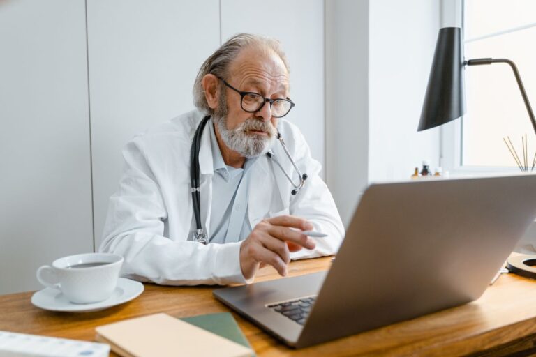 Provider working on a laptop at a clinic desk