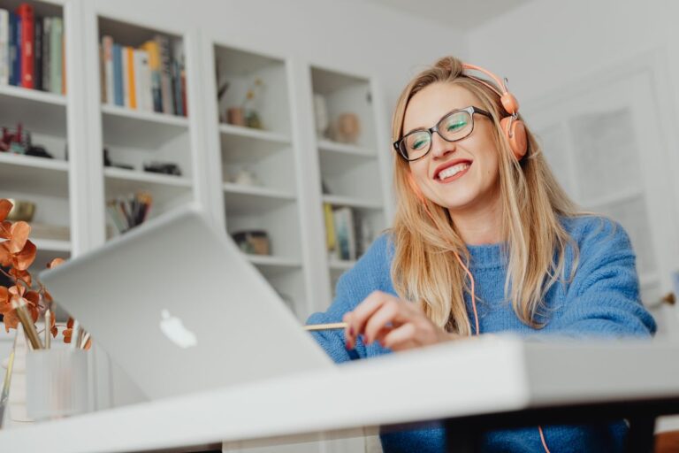 Smiling virtual assistant wearing headphones and working on a laptop